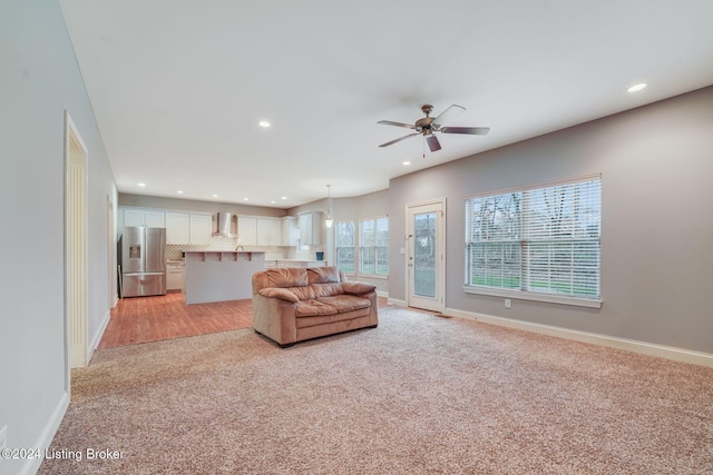 living room with ceiling fan and light colored carpet