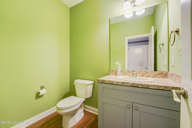 bathroom with hardwood / wood-style floors, vanity, and toilet