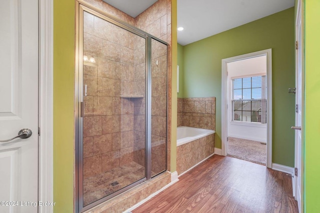 bathroom featuring hardwood / wood-style floors and shower with separate bathtub