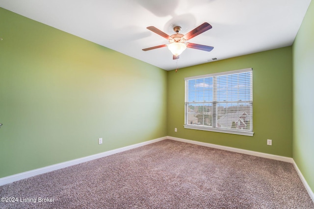 carpeted spare room featuring ceiling fan