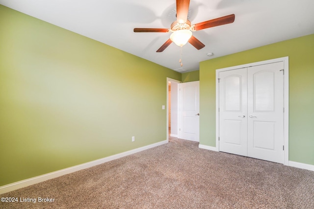 unfurnished bedroom featuring ceiling fan, a closet, and carpet floors