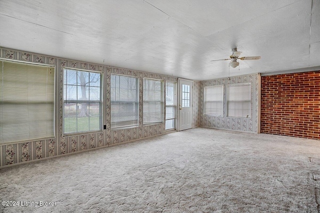 unfurnished sunroom featuring ceiling fan