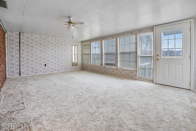 unfurnished sunroom featuring ceiling fan