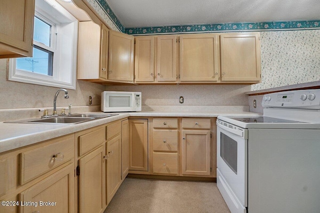 kitchen featuring light brown cabinets, white appliances, and sink