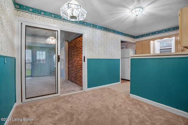 unfurnished room with light colored carpet, a textured ceiling, and a chandelier