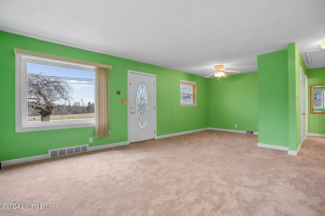 foyer featuring ceiling fan and light colored carpet