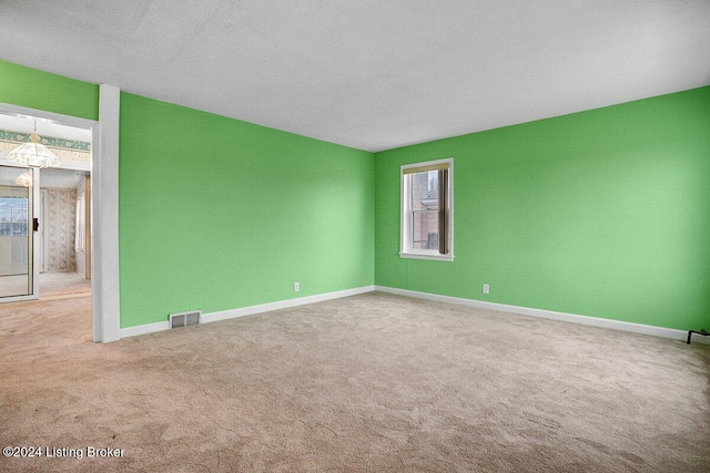 carpeted empty room with a textured ceiling