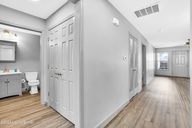 hallway featuring sink and light wood-type flooring