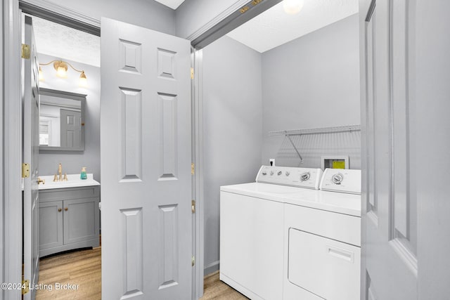 washroom featuring sink, washer and dryer, and light hardwood / wood-style floors