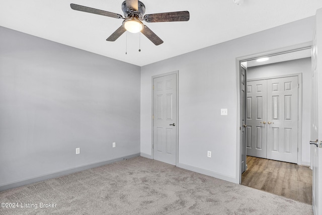 unfurnished bedroom with ceiling fan and light colored carpet