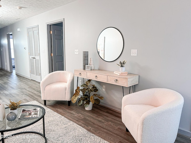 sitting room featuring wood-type flooring and a textured ceiling