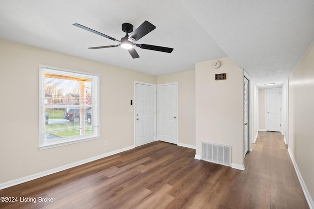 spare room with ceiling fan, dark wood-type flooring, and a textured ceiling