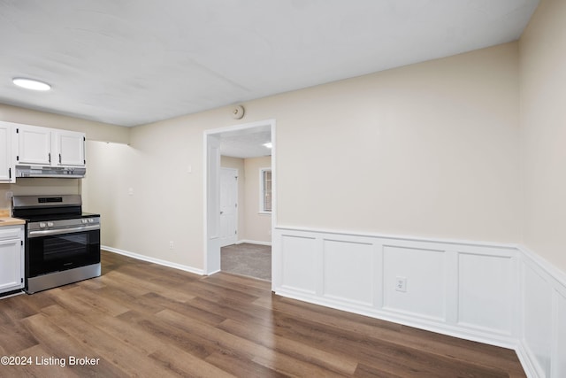 kitchen with white cabinetry, stainless steel range oven, and hardwood / wood-style flooring