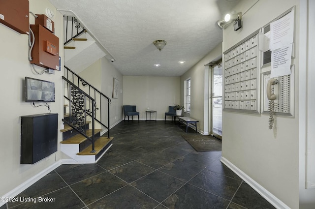 interior space with mail boxes and a textured ceiling