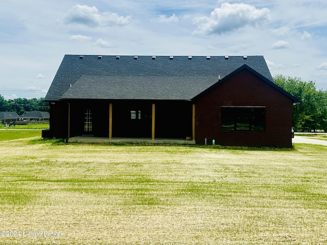 rear view of house featuring a yard