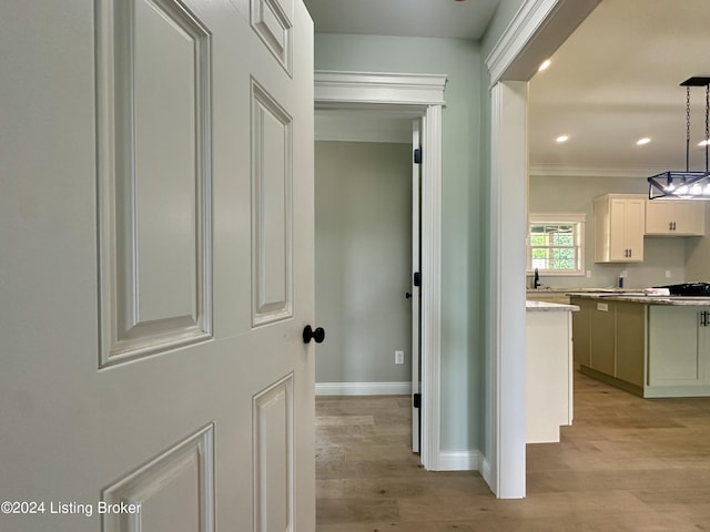 hallway featuring ornamental molding and light wood-type flooring