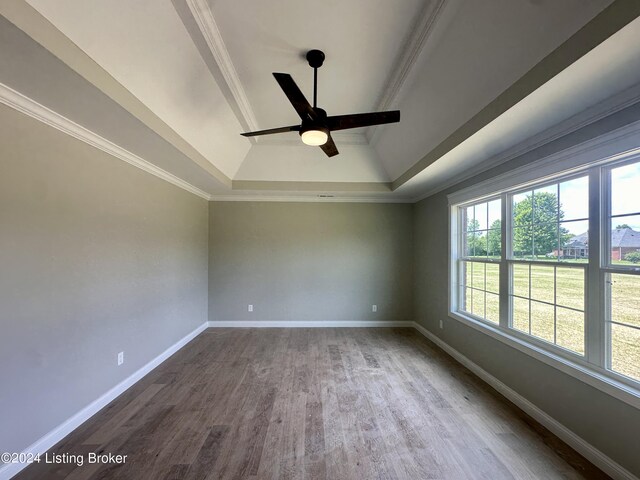 spare room with a tray ceiling, crown molding, ceiling fan, and wood-type flooring