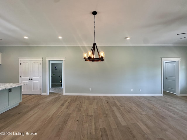 unfurnished dining area with crown molding, light hardwood / wood-style floors, and ceiling fan with notable chandelier