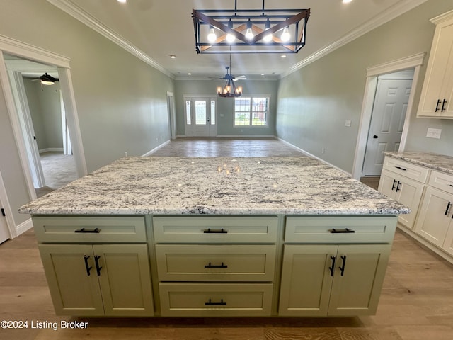 kitchen with crown molding, pendant lighting, ceiling fan with notable chandelier, and light wood-type flooring