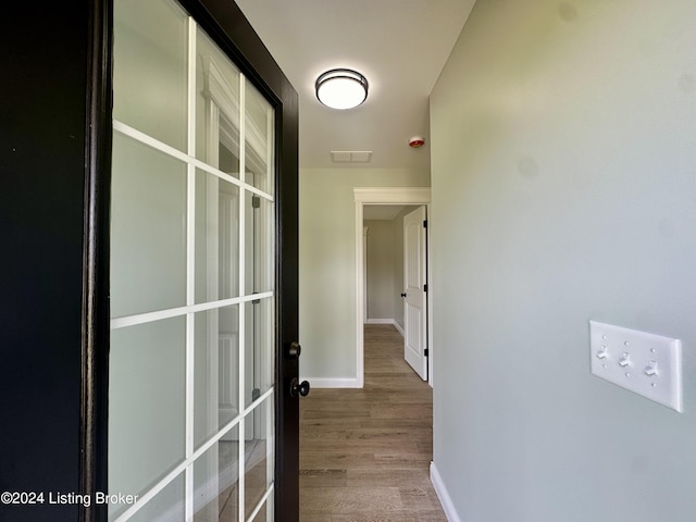 corridor with hardwood / wood-style flooring