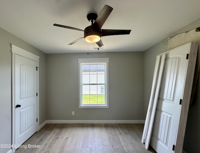 unfurnished bedroom with ceiling fan, a closet, and light hardwood / wood-style flooring