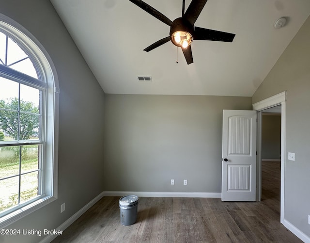 additional living space featuring hardwood / wood-style flooring, vaulted ceiling, a wealth of natural light, and ceiling fan