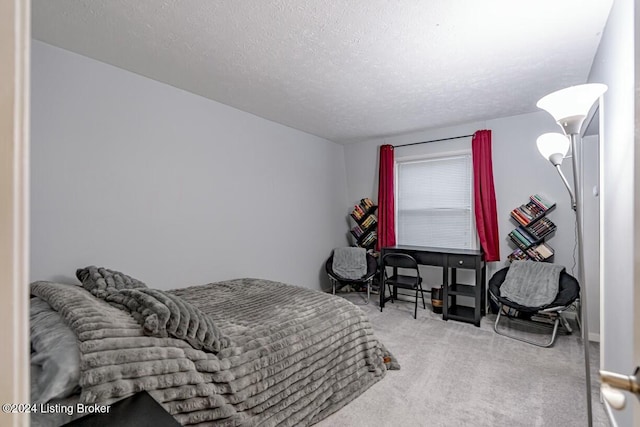 bedroom with a textured ceiling and light carpet