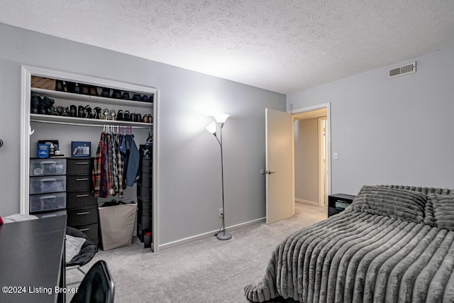 carpeted bedroom featuring a closet and a textured ceiling