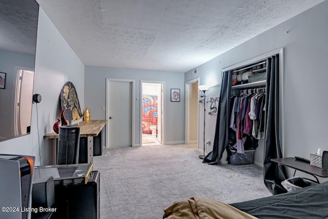 bedroom featuring light carpet, a textured ceiling, connected bathroom, and a closet