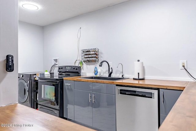 kitchen featuring black range with electric stovetop, sink, stainless steel dishwasher, gray cabinets, and washer / clothes dryer