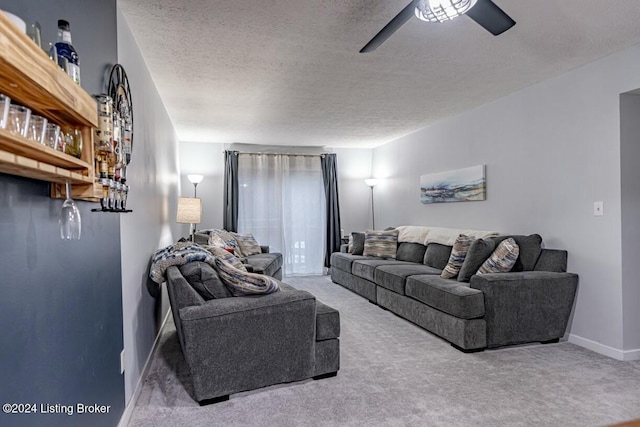 carpeted living room featuring a textured ceiling and ceiling fan