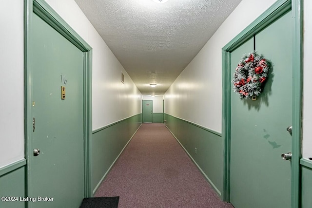 corridor featuring carpet floors and a textured ceiling