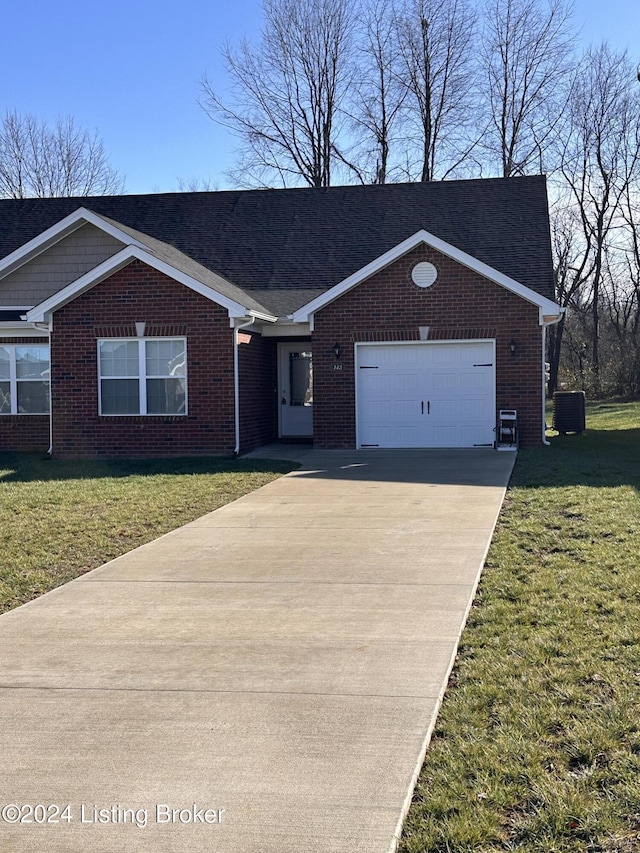 ranch-style house featuring a garage, central air condition unit, and a front yard