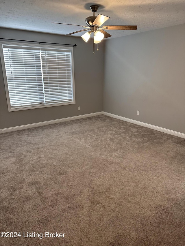 carpeted spare room featuring a textured ceiling and ceiling fan