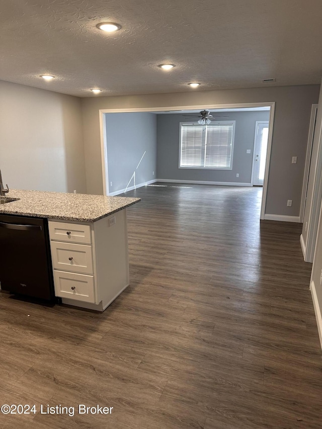 kitchen featuring light stone countertops, white cabinets, dark wood-type flooring, sink, and dishwasher