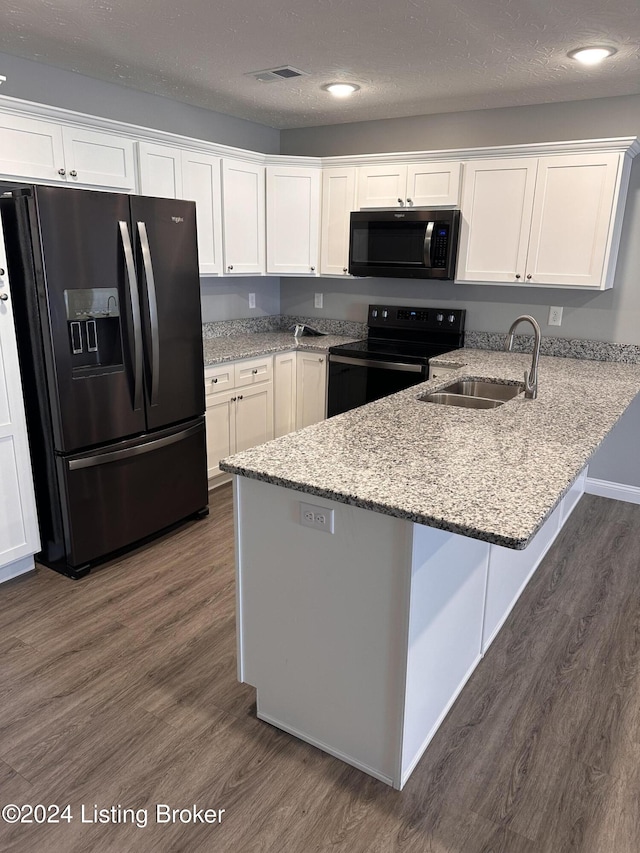 kitchen with black appliances, dark hardwood / wood-style flooring, kitchen peninsula, and sink