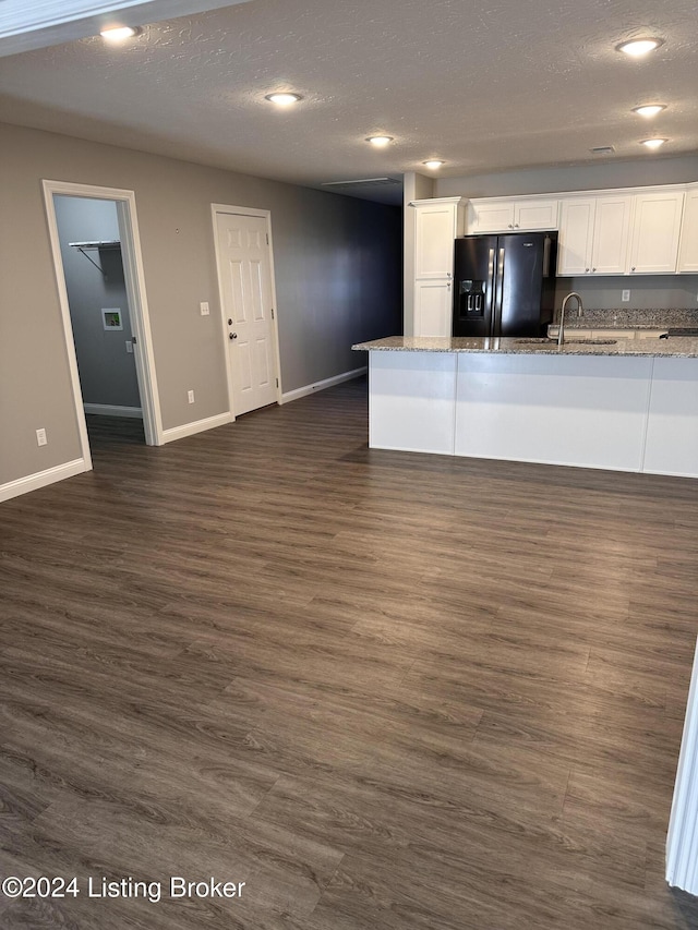 kitchen featuring white cabinets, dark hardwood / wood-style flooring, black fridge with ice dispenser, and light stone countertops