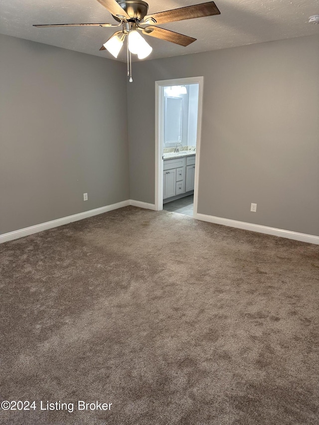 spare room with ceiling fan, sink, carpet floors, and a textured ceiling