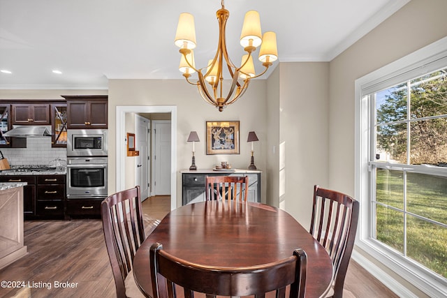 dining room featuring a chandelier, ornamental molding, and dark wood-type flooring