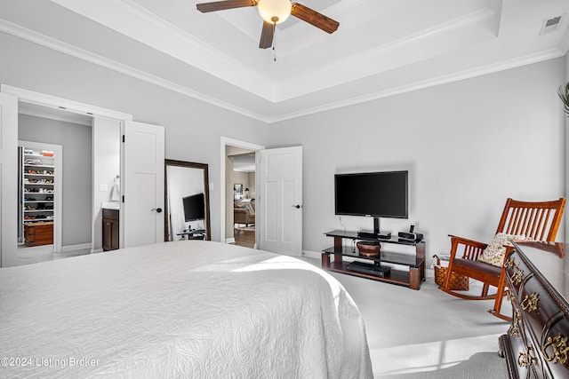 carpeted bedroom featuring ceiling fan, crown molding, connected bathroom, and a tray ceiling