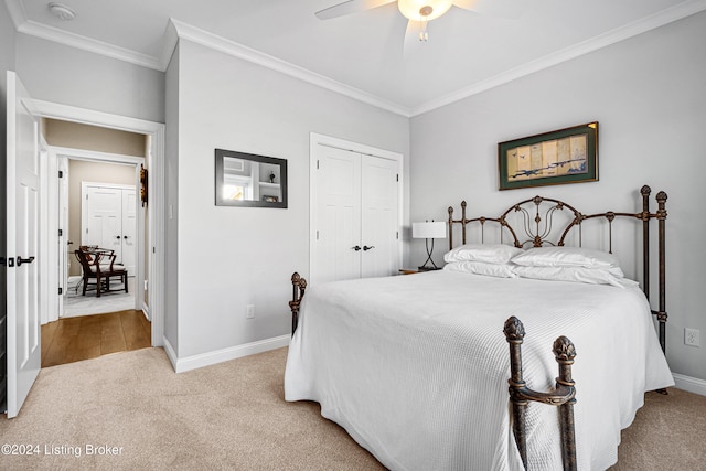 carpeted bedroom with ceiling fan, crown molding, and a closet