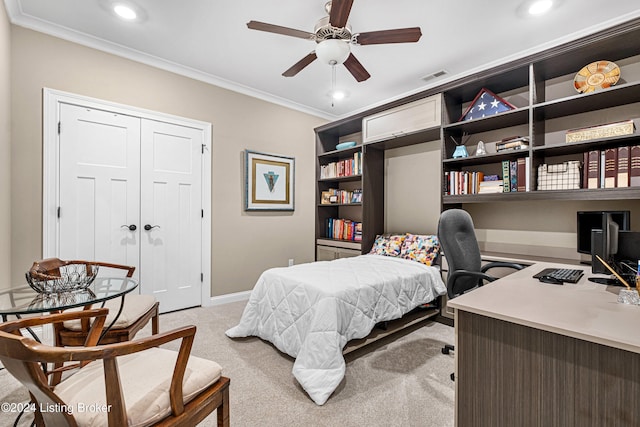 bedroom featuring light carpet, a closet, ceiling fan, and crown molding