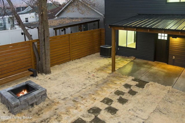 exterior space with central AC unit and an outdoor fire pit