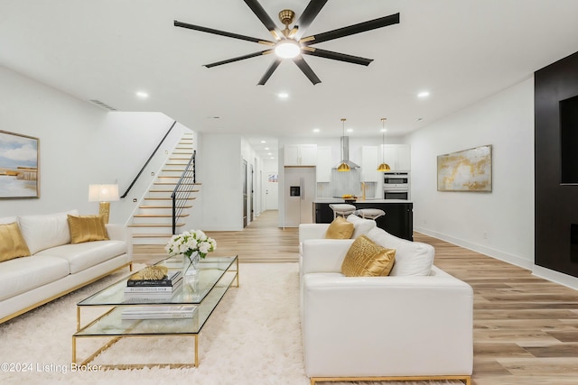 living room featuring ceiling fan and light hardwood / wood-style flooring