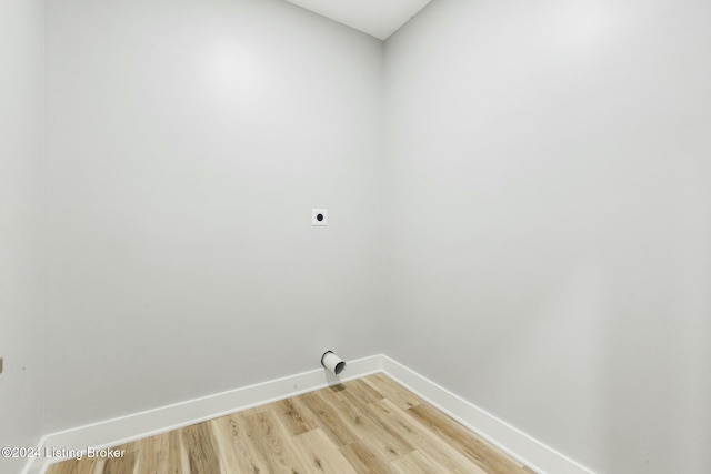 clothes washing area featuring hookup for an electric dryer and light hardwood / wood-style flooring