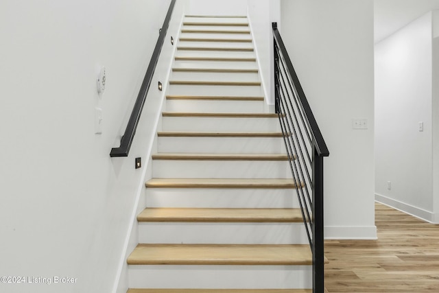 stairs with hardwood / wood-style flooring