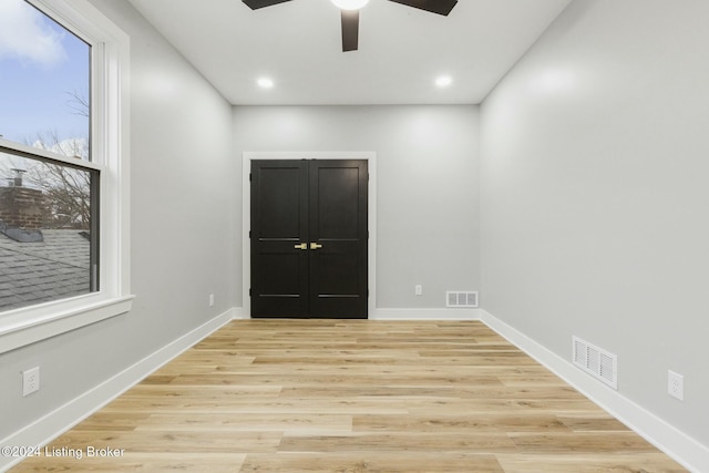 empty room with ceiling fan and light hardwood / wood-style floors