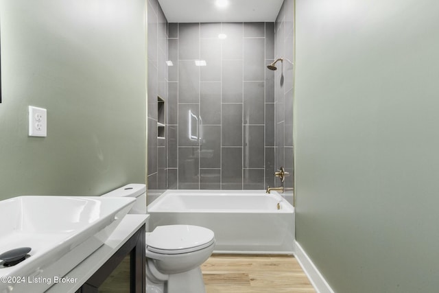 full bathroom featuring vanity, toilet, tiled shower / bath, and hardwood / wood-style flooring