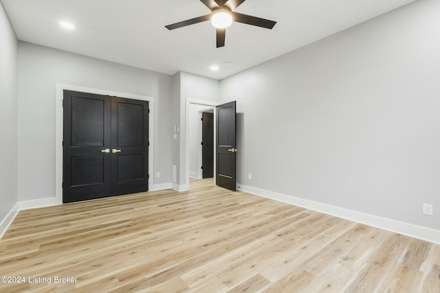 unfurnished bedroom with light wood-type flooring, a closet, and ceiling fan