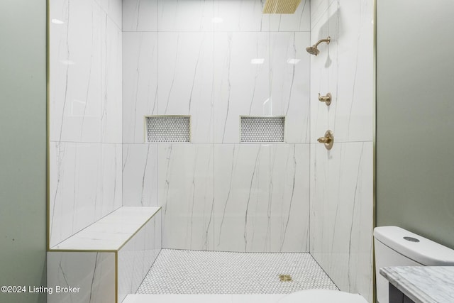 bathroom with toilet and a tile shower